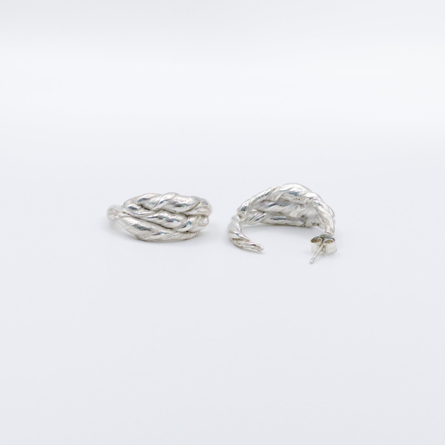 A pair of Anchor silver hoop earrings, front and back views, pictured on a light plain background.