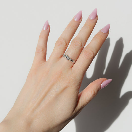 Hand wearing the Atoll textured silver ring on a plain background.