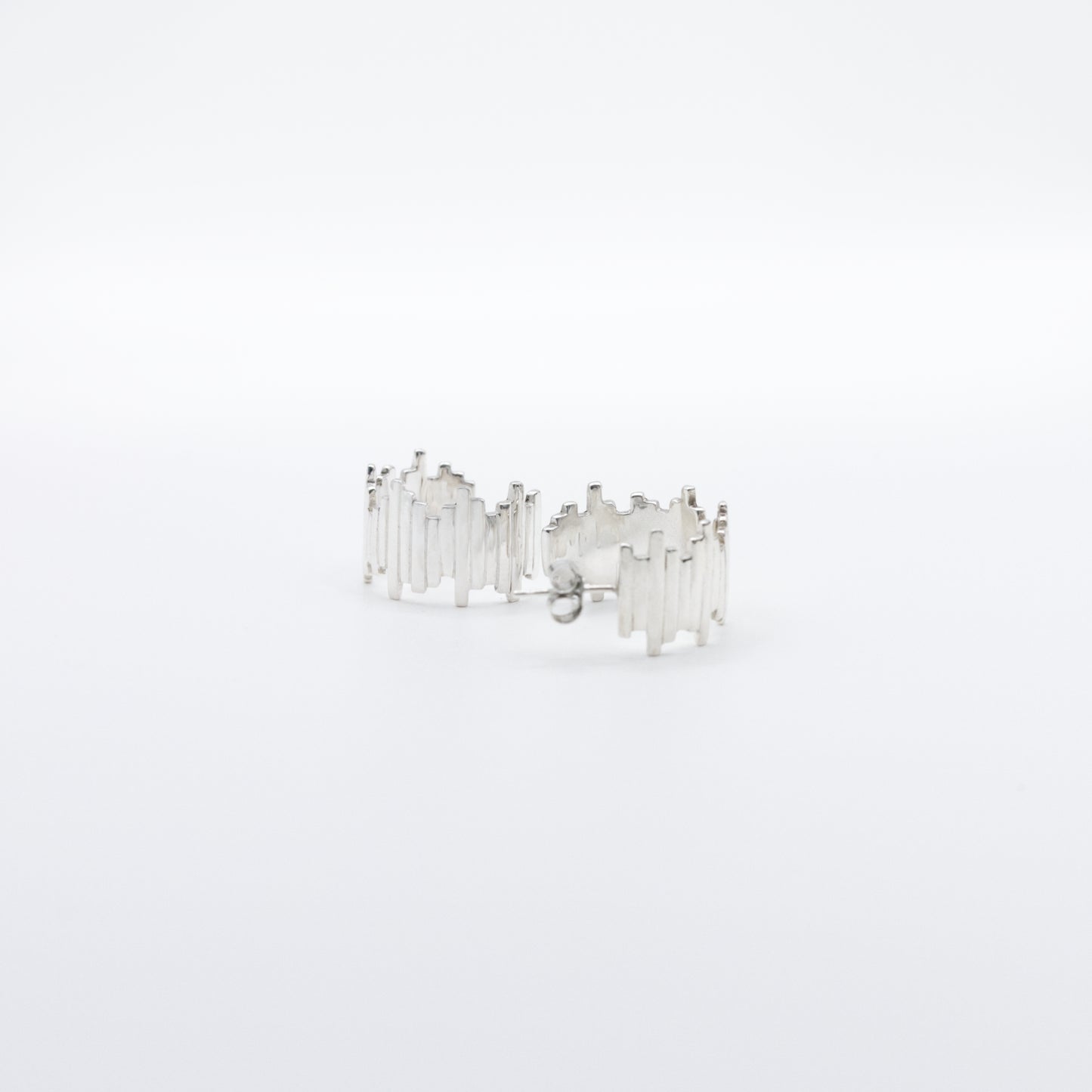 A pair of Guidance silver hoop earrings, front and back views, pictured on a light plain background.