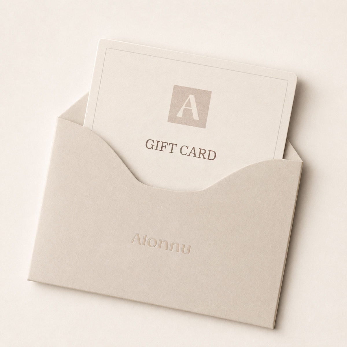 A personalized gift card with a monogram 'A' and the text 'GIFT CARD' tucked inside a neutral beige envelope embossed with the name 'Aionnu'.