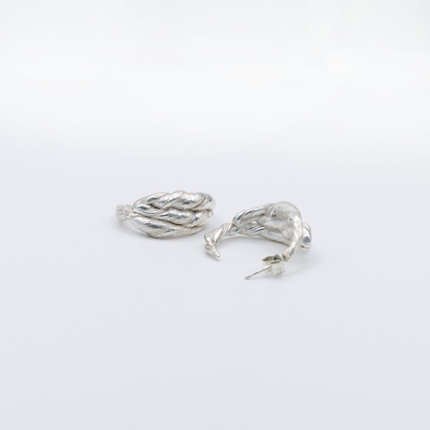 A pair of Anchor silver hoop earrings, front and back views, pictured on a light plain background.