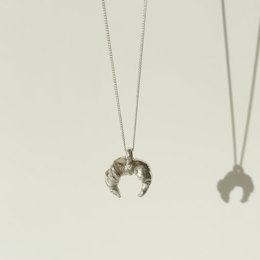 Front view of the Arc textured silver pendant on a chain, pictured on a light plain background.