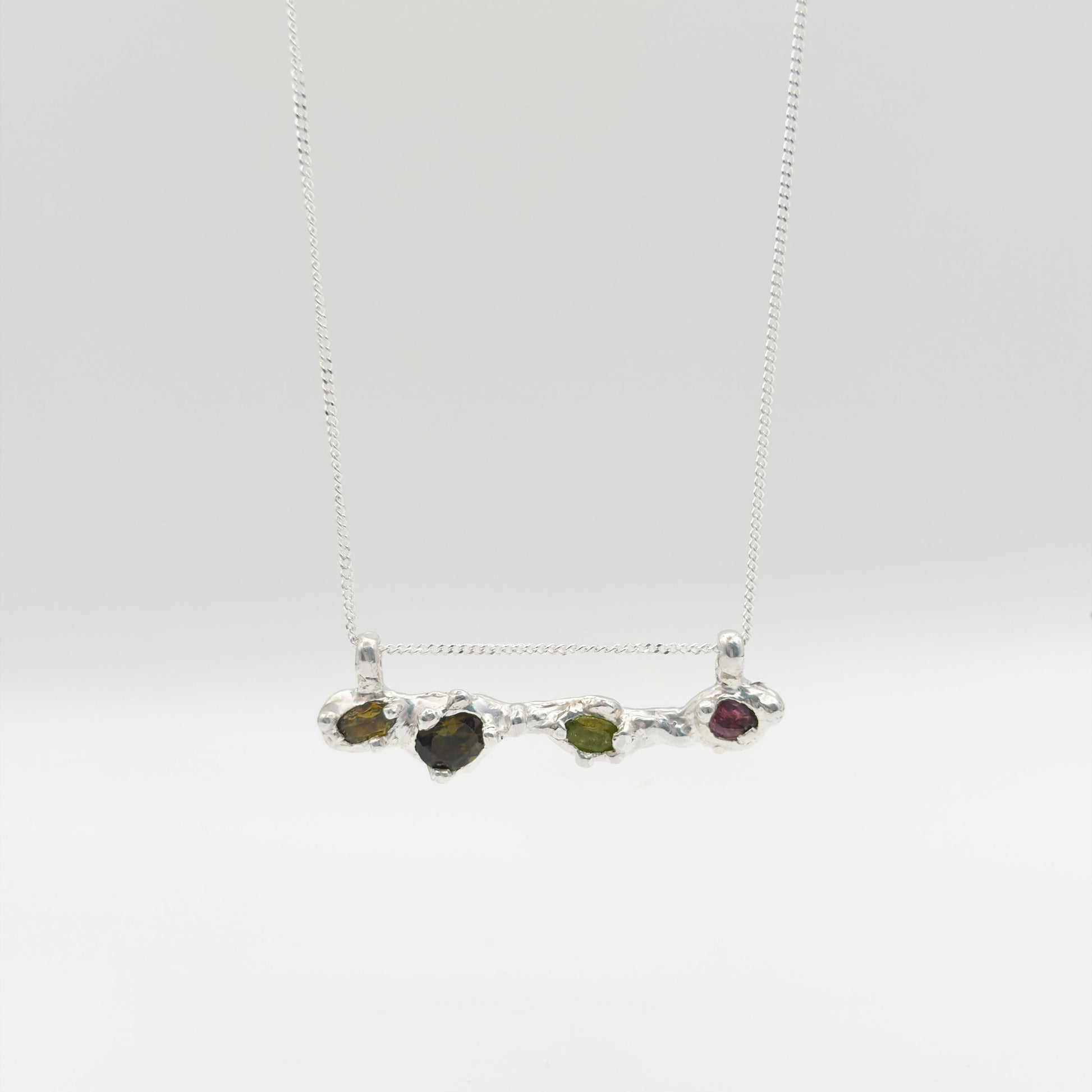Front view of the Atoll Editions No1 silver necklace, featuring a textured bar pendant with multicolored tourmalines. Shown on a plain light background.