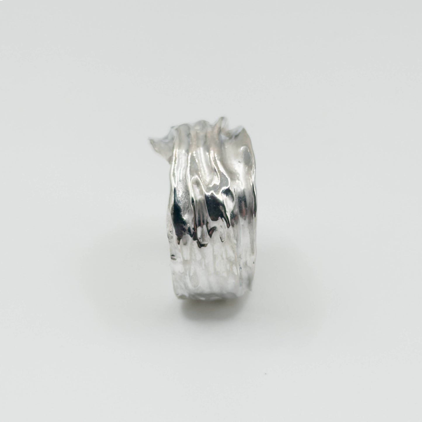 Side view of the Canyon sample silver ring, pictured on a light plain background.