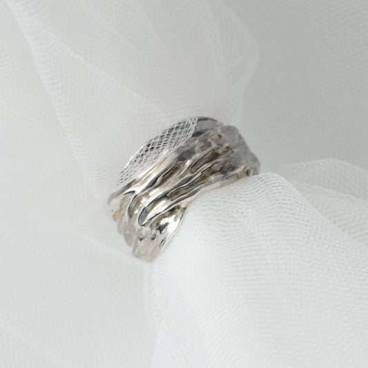 Front view of the Canyon sample silver ring, pictured on a light textured background.