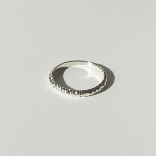 Front view of the Echo ring - a thin silver band ring with a textured surface, photographed on a plain light gray background.