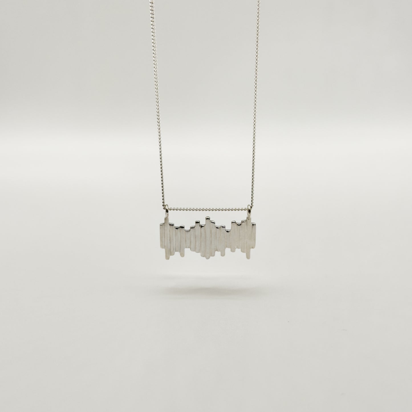 Front view of the Guidance textured silver necklace, pictured on a light plain background.