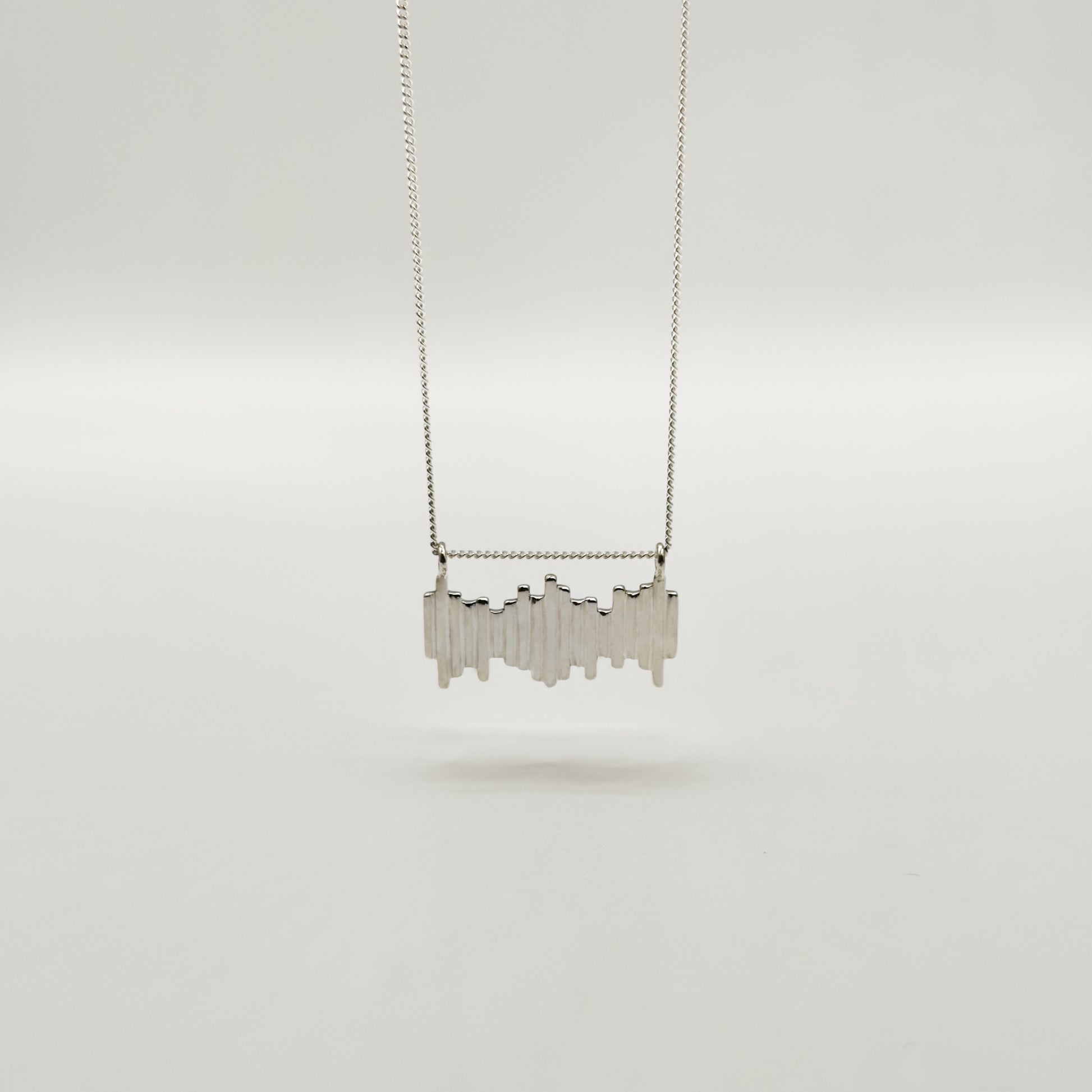Front view of the Guidance textured silver necklace, pictured on a light plain background.