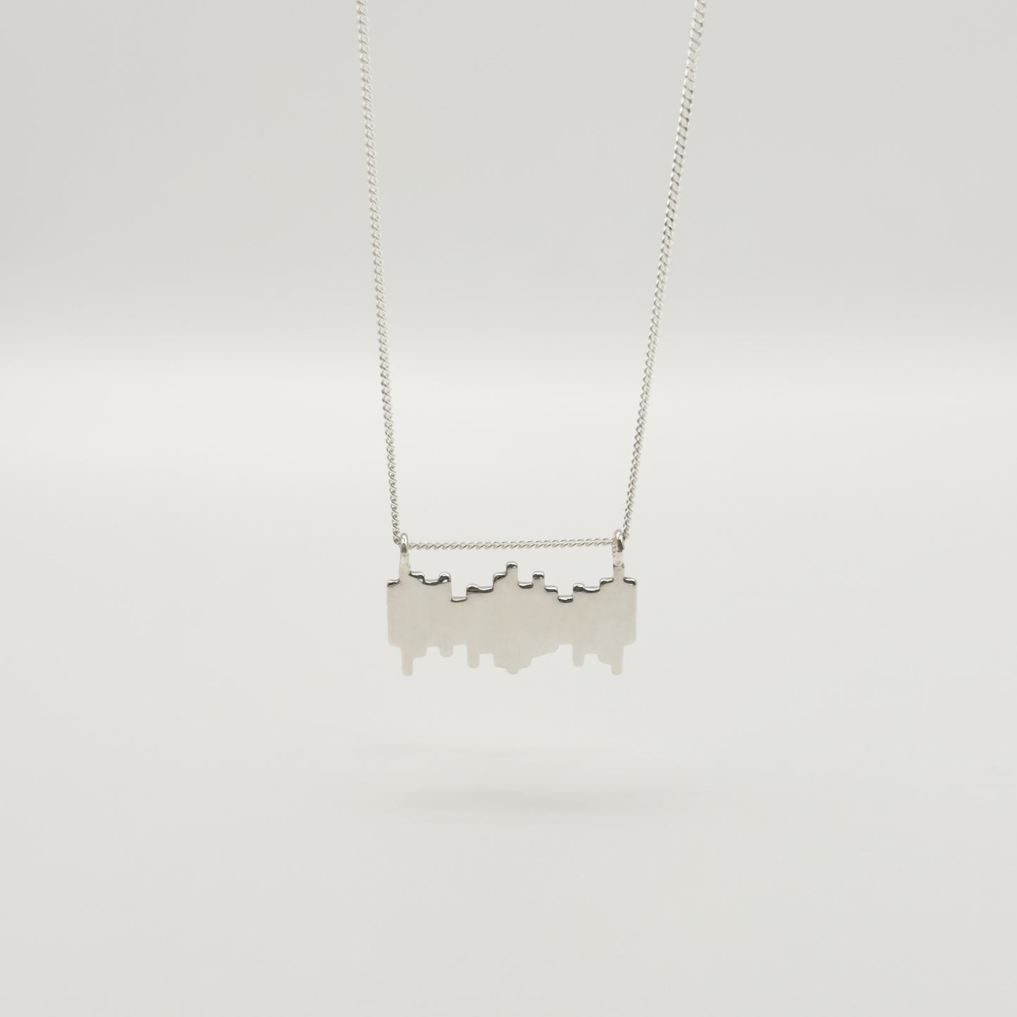 Back view of the Guidance textured silver necklace, pictured on a light plain background.