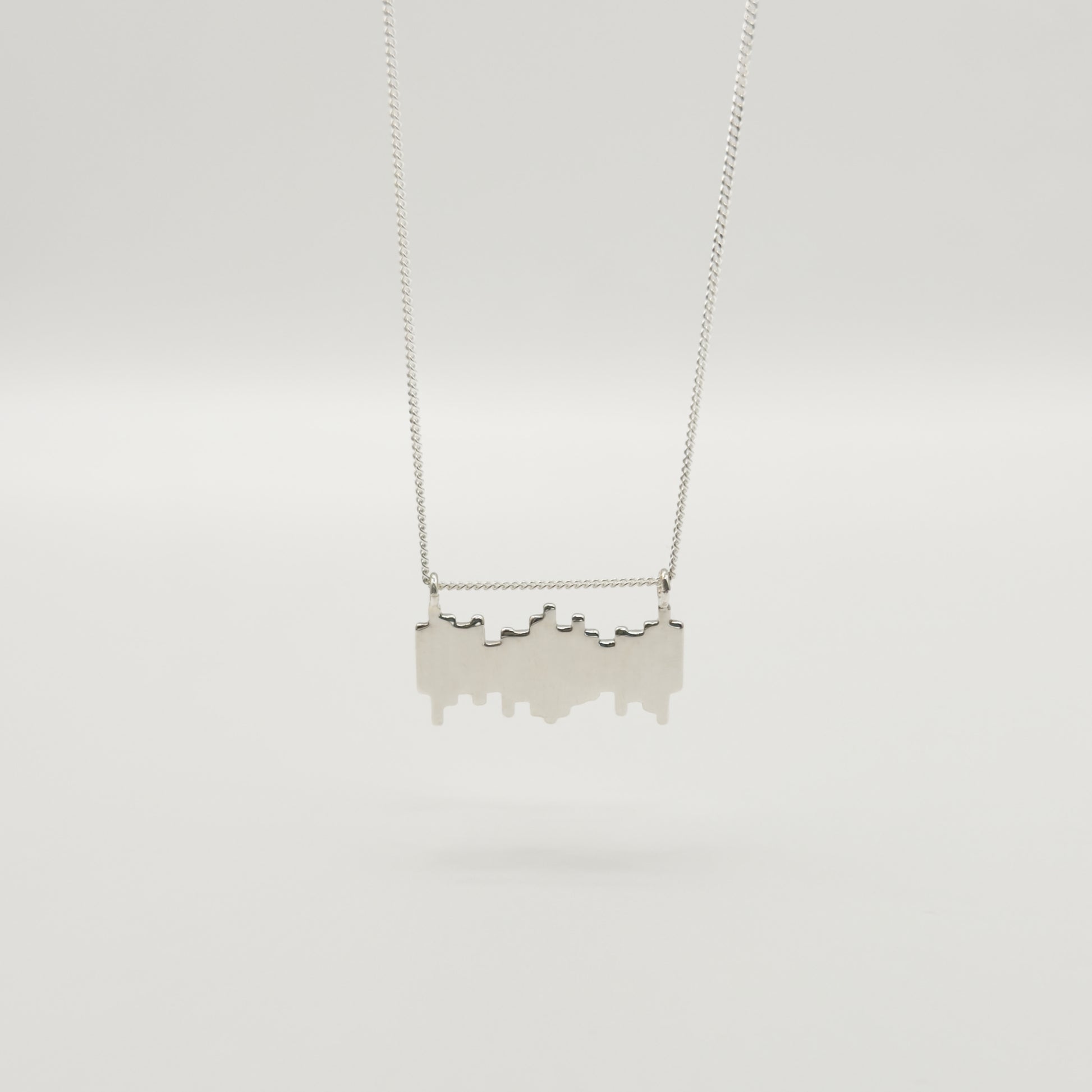 Back view of the Guidance textured silver necklace, pictured on a light plain background.
