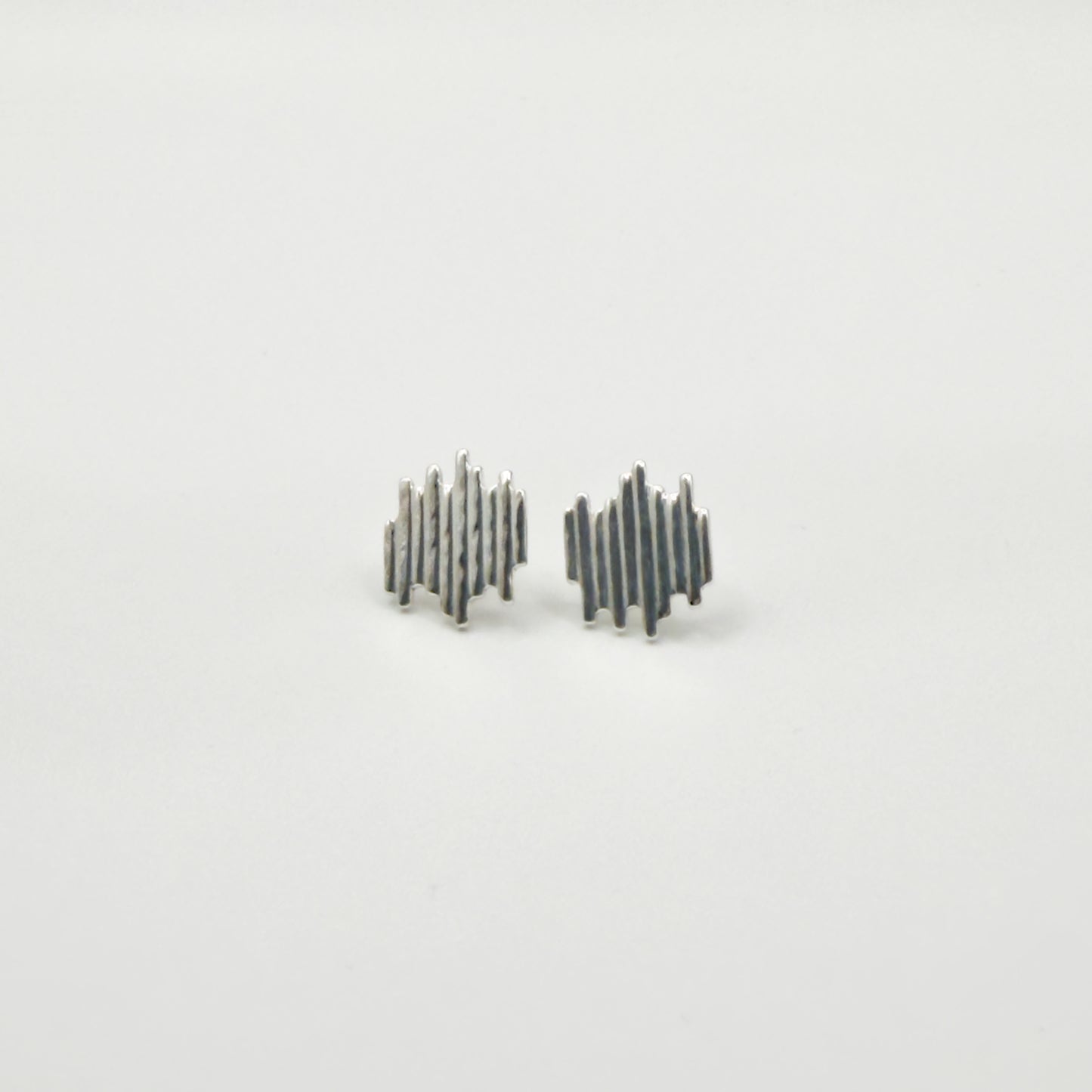 Front view of the Guidance textured silver stud earrings, pictured on a light plain background.