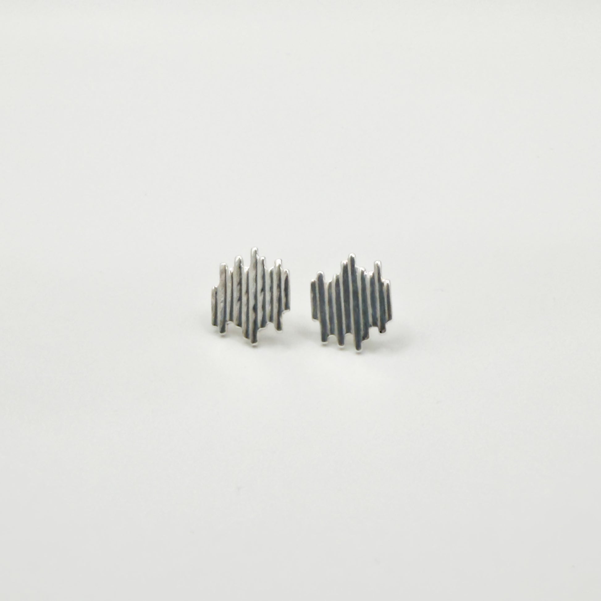 Front view of the Guidance textured silver stud earrings, pictured on a light plain background.