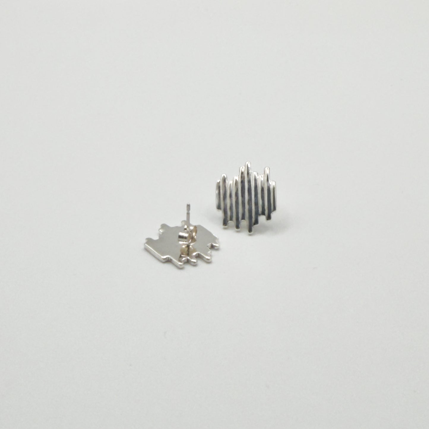 Front and back view of the Guidance textured silver stud earrings, pictured on a light plain background.