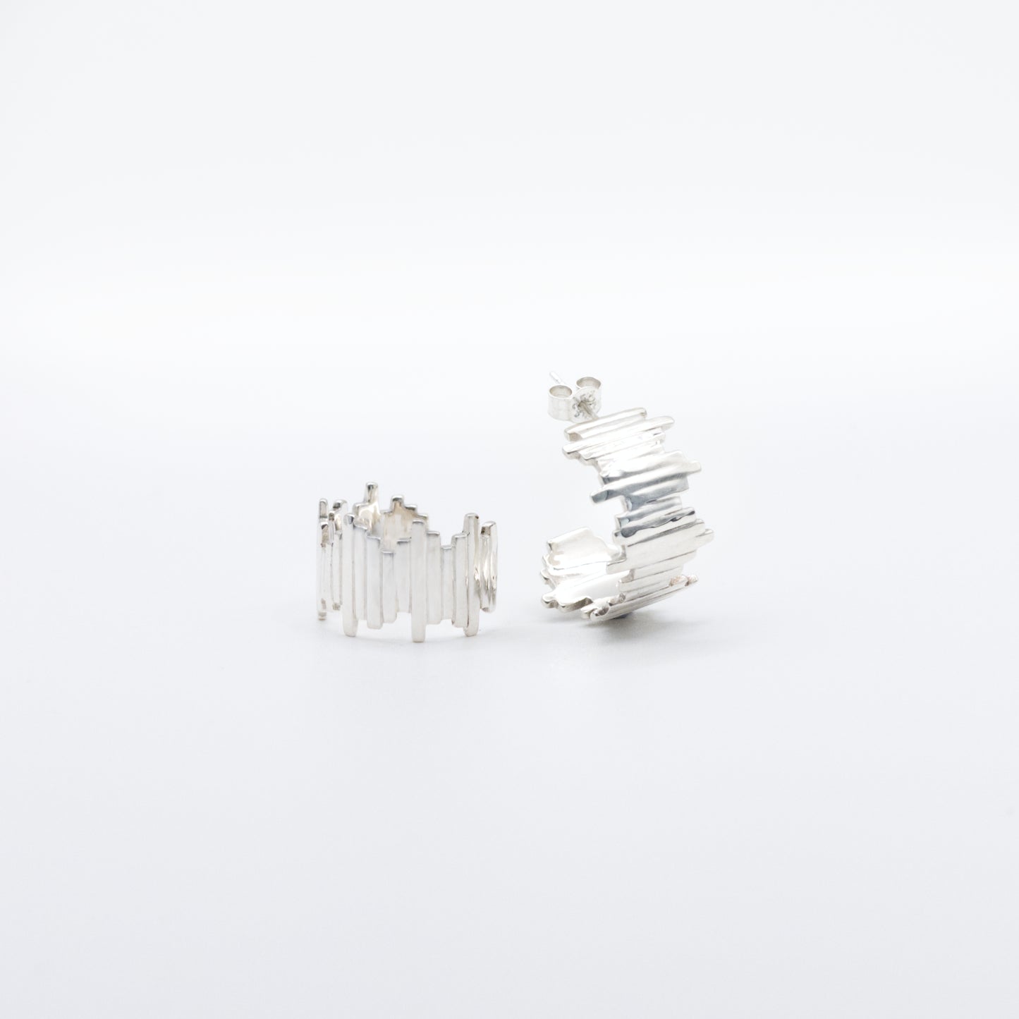 A pair of Guidance silver hoop earrings, angled front and side views, pictured on a light plain background.