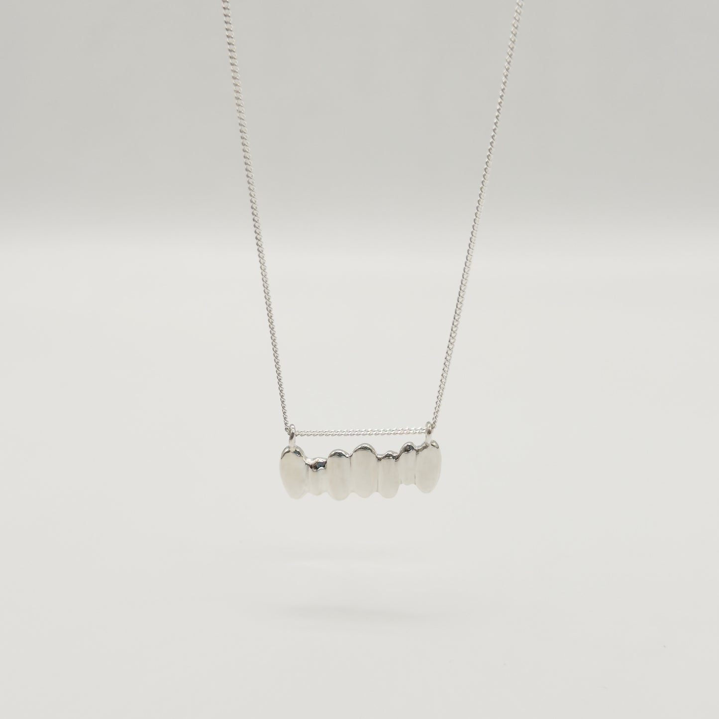 Front view of the Meridian textured silver necklace, pictured on a light plain background.