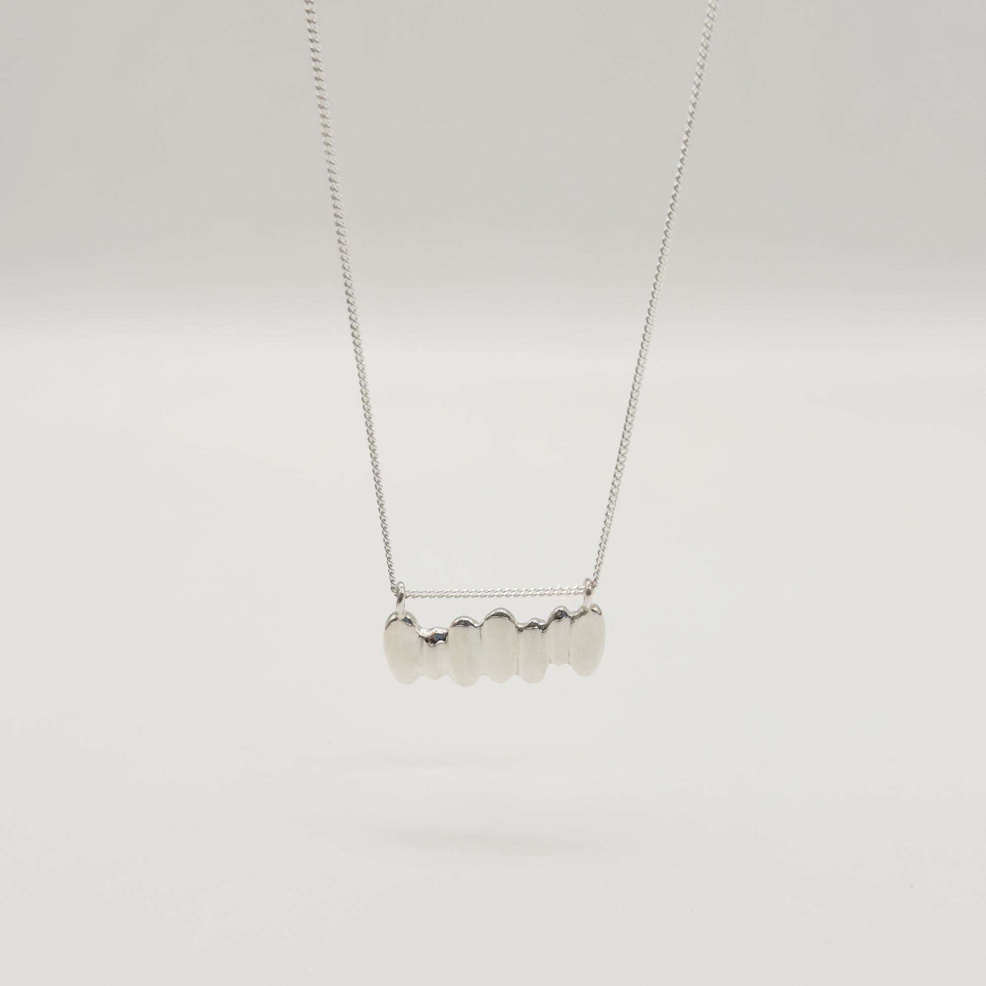 Front view of the Meridian textured silver necklace, pictured on a light plain background.