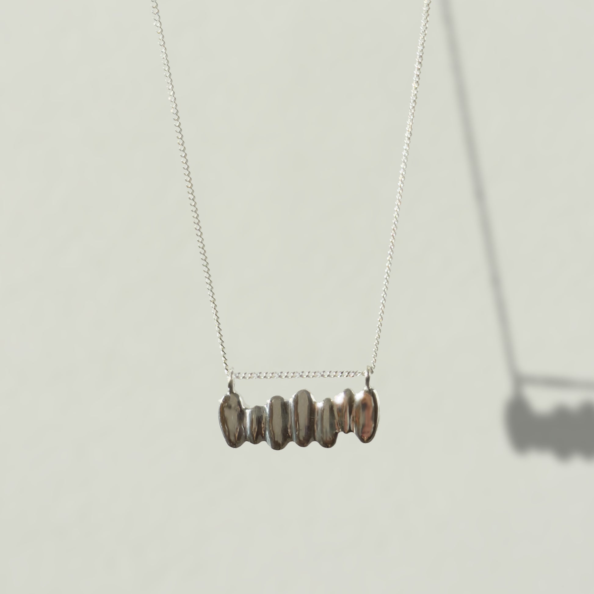Front view of the Meridian textured silver necklace, pictured on a light plain background.