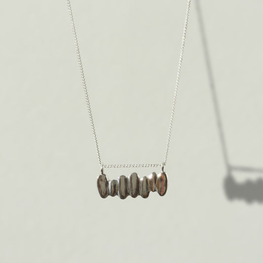 Front view of the Meridian textured silver necklace, pictured on a light plain background.