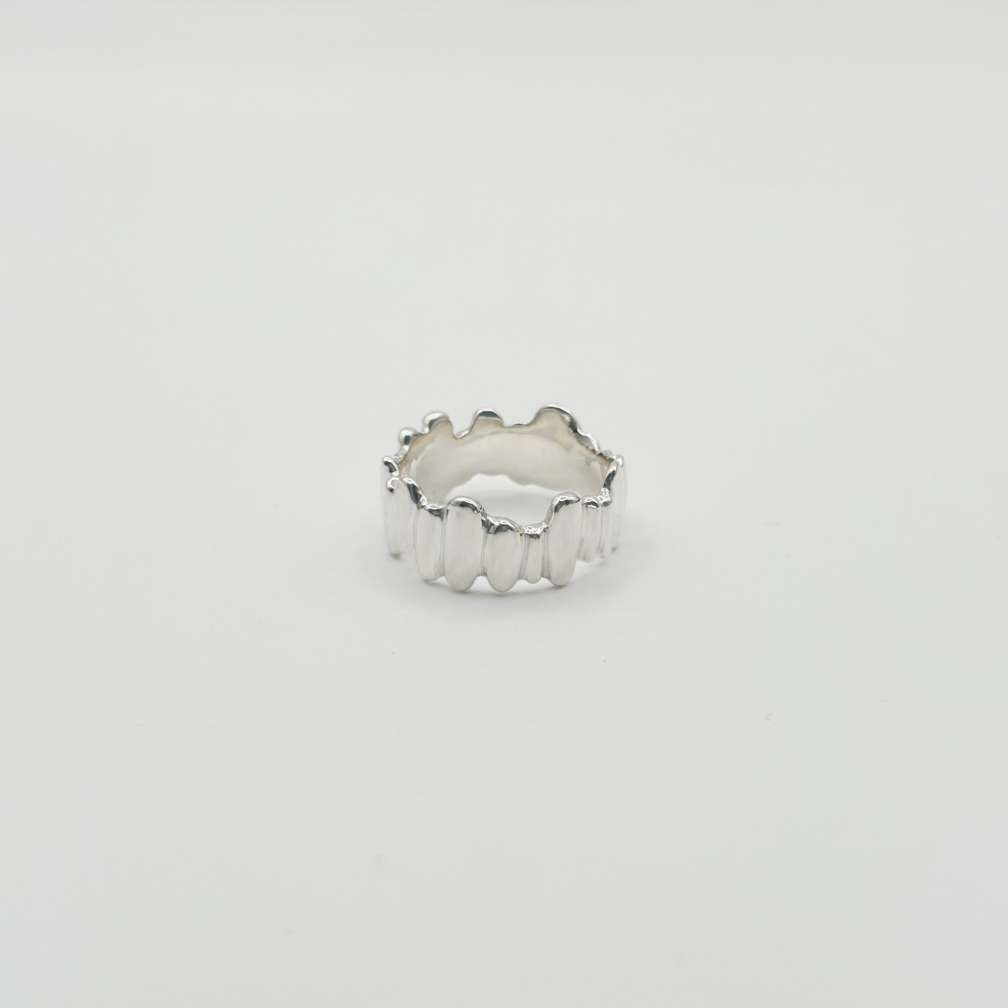 Front view of the Meridian textured silver ring, pictured on a light plain background.