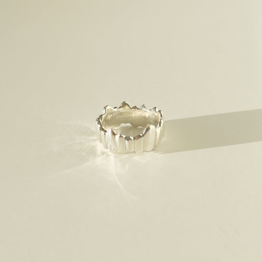 Side view of the Meridian textured silver ring, pictured on a light plain background.
