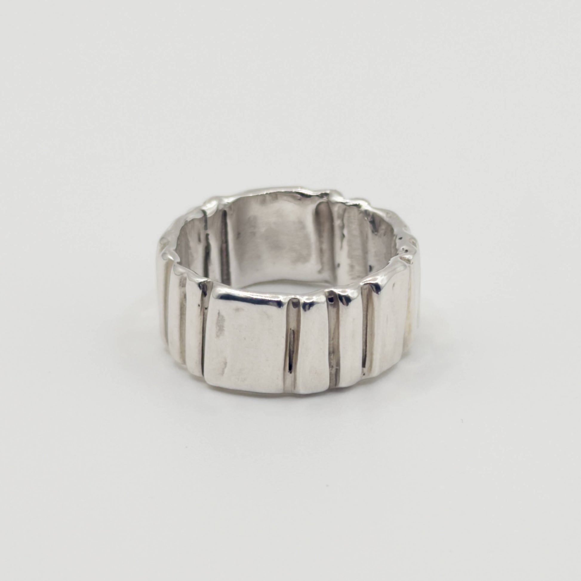 Side view of the Ripple silver ring, pictured on a light plain background.
