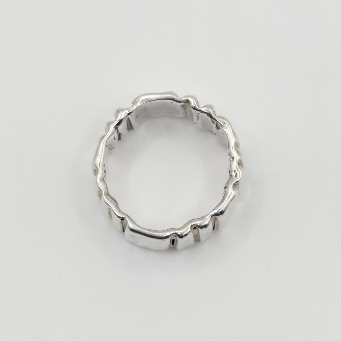 Top view of the Ripple silver ring, pictured on a light plain background.