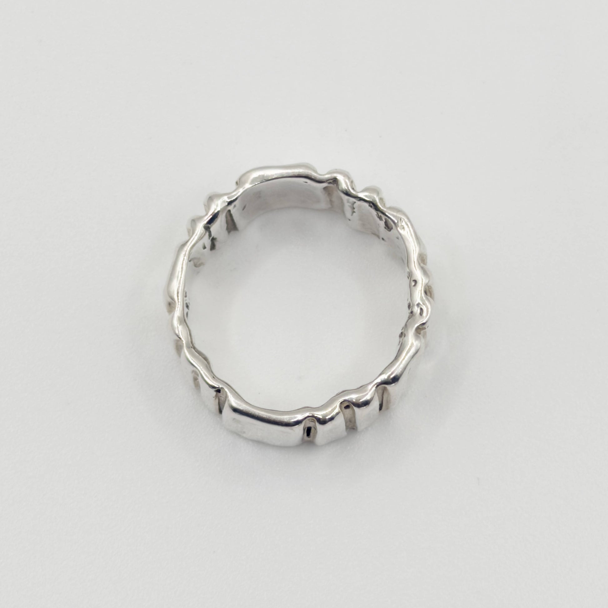 Top view of the Ripple silver ring, pictured on a light plain background.
