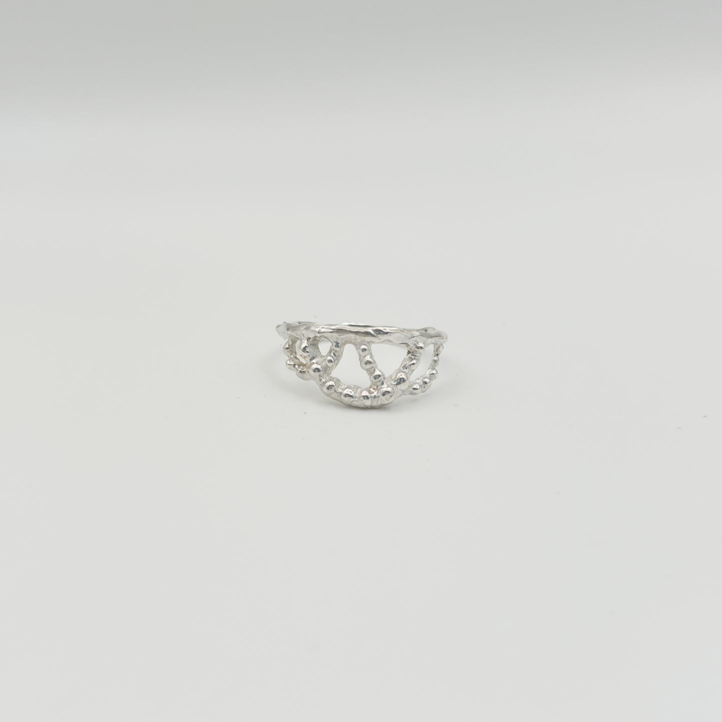 Front view of the Sequence textured silver ring, pictured on a light plain background.