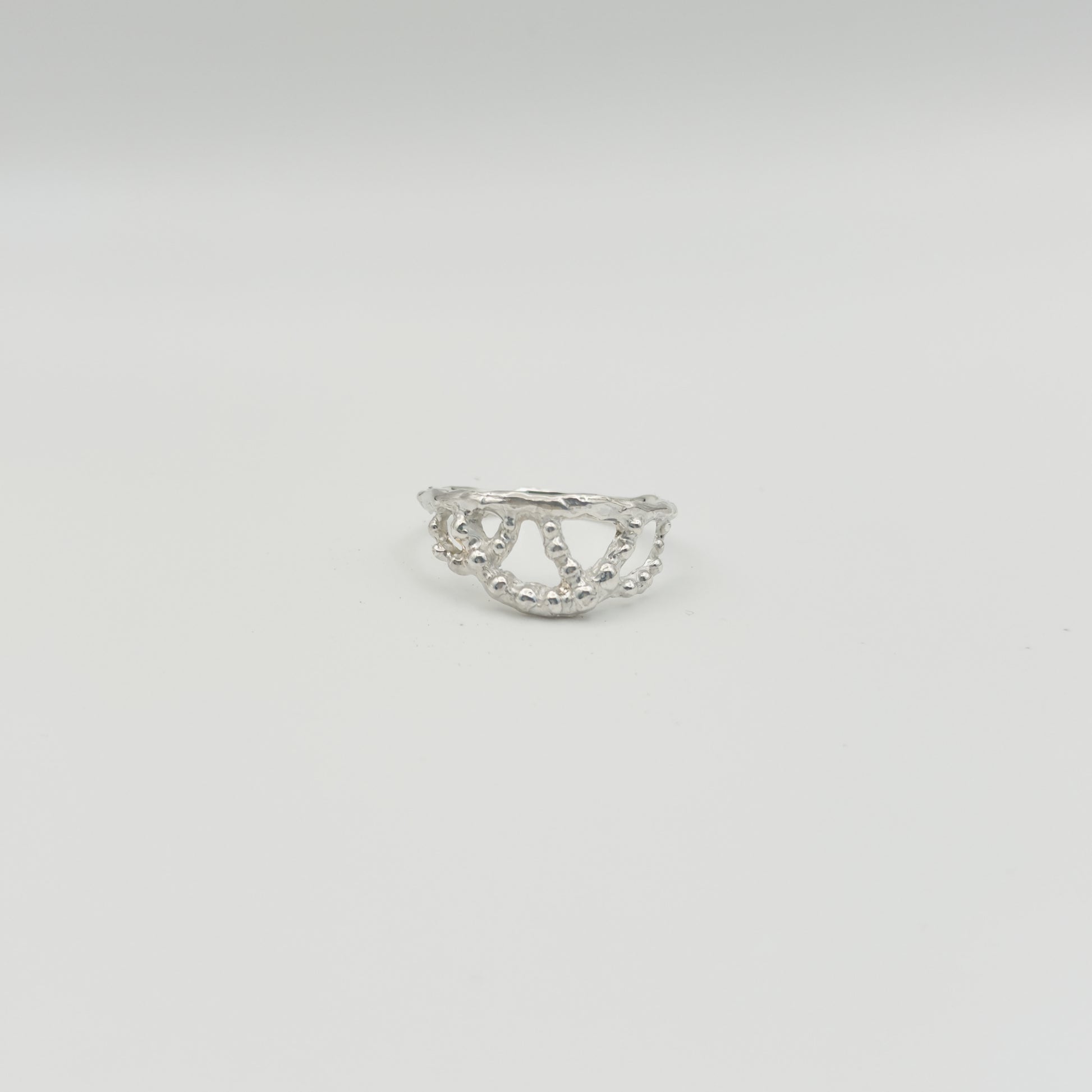 Front view of the Sequence textured silver ring, pictured on a light plain background.