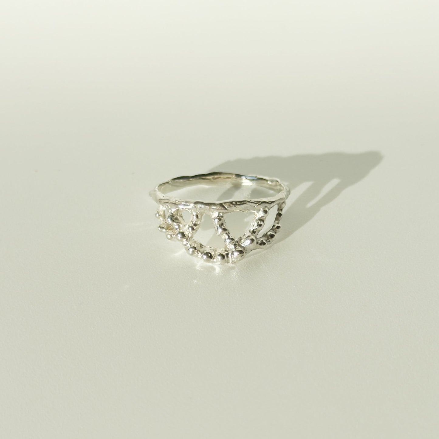 Front view of the Sequence textured silver ring, pictured on a light plain background.