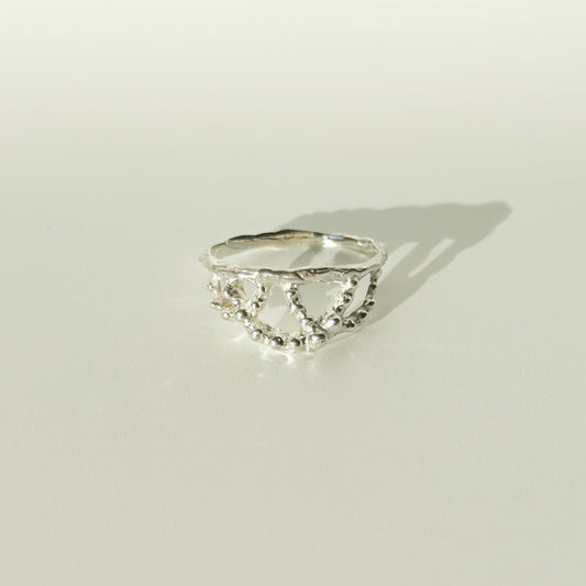 Front view of the Sequence textured silver ring, pictured on a light plain background.