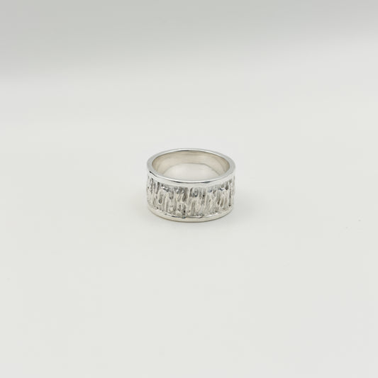 Front view of the Solace textured silver ring, pictured on a light plain background.