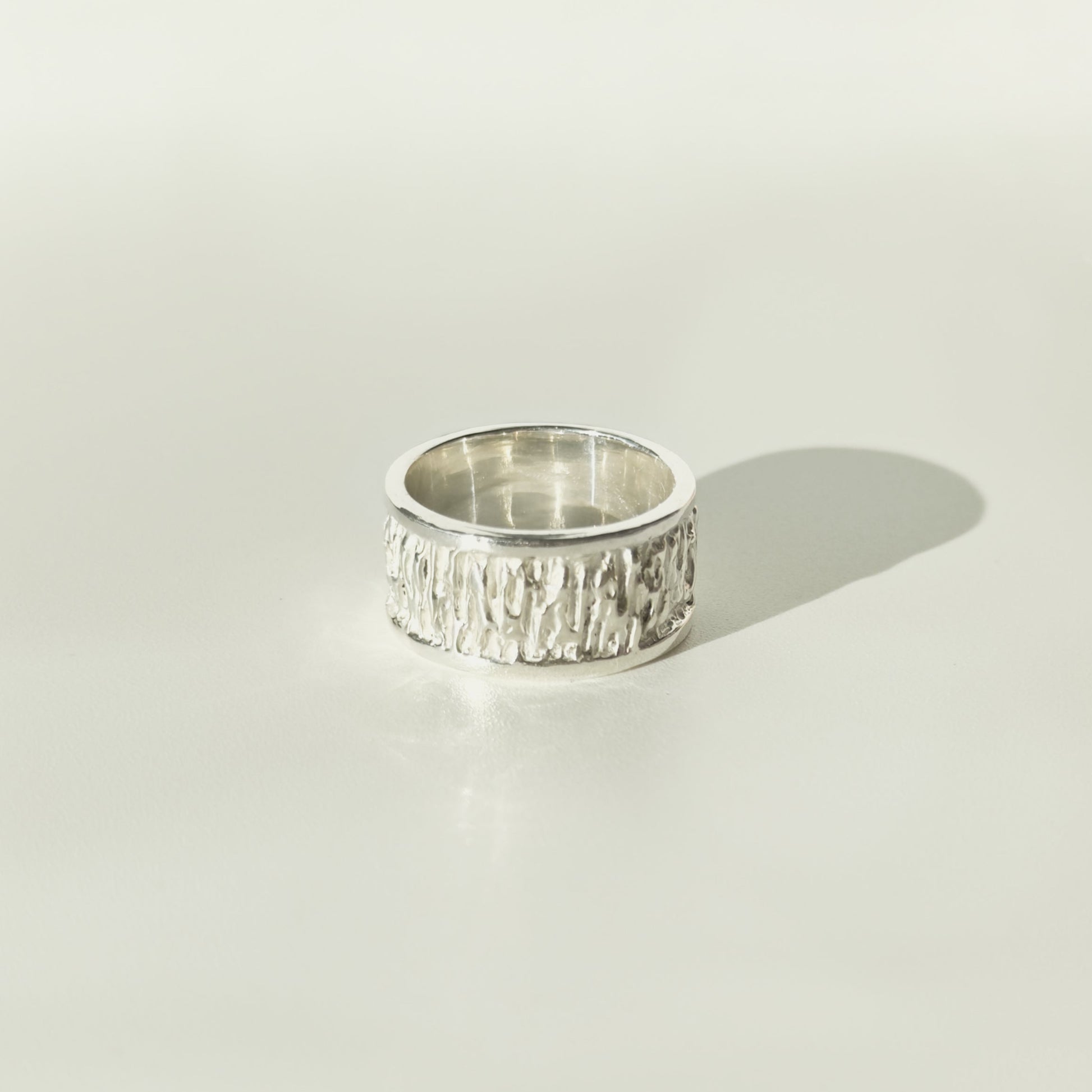 Front view of the Solace textured silver ring, pictured on a light plain background.