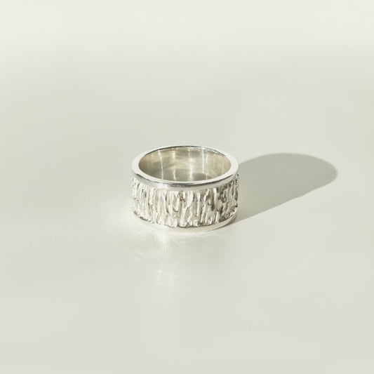 Front view of the Solace textured silver ring, pictured on a light plain background.