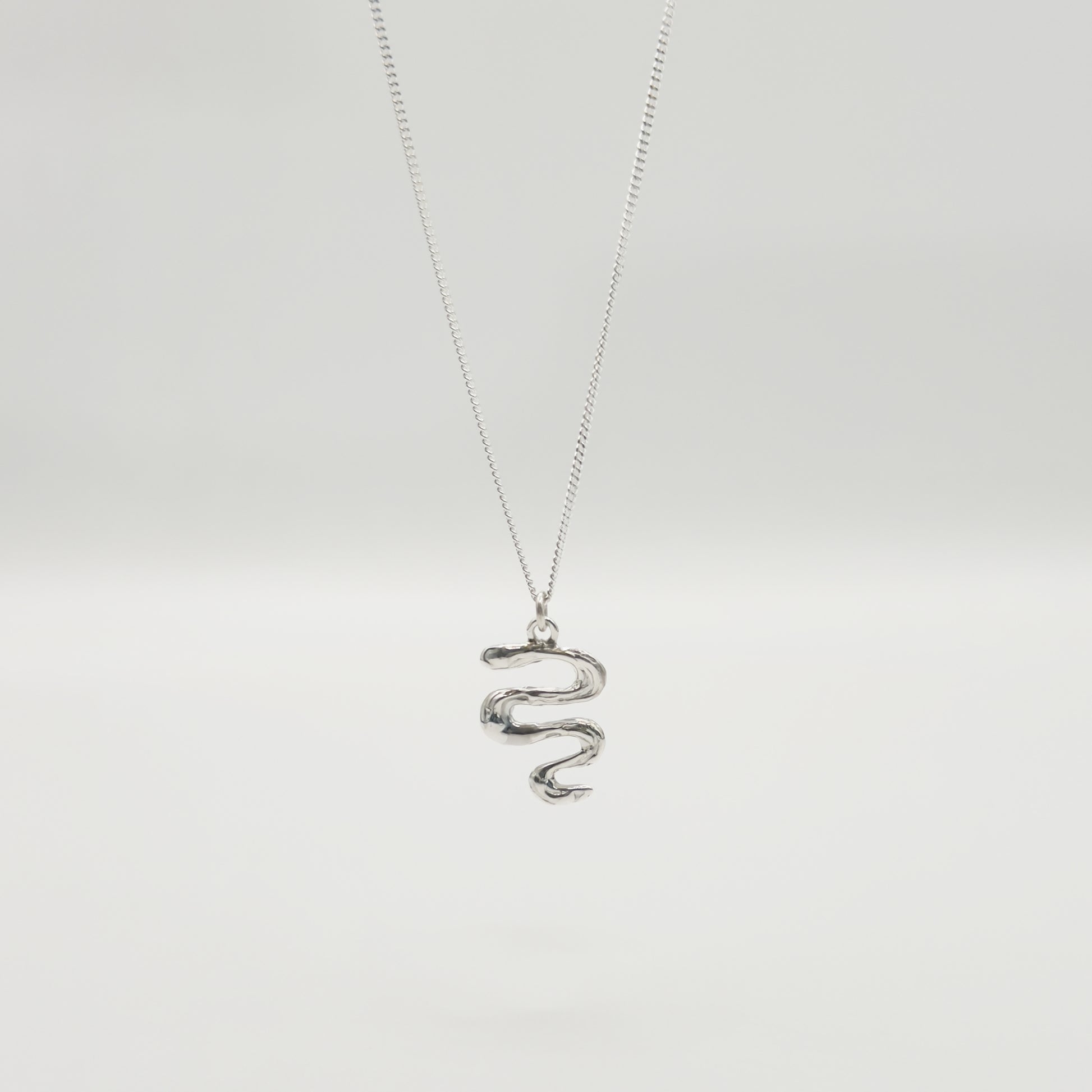 Front view of the Unfold textured silver necklace, pictured on a light plain background.