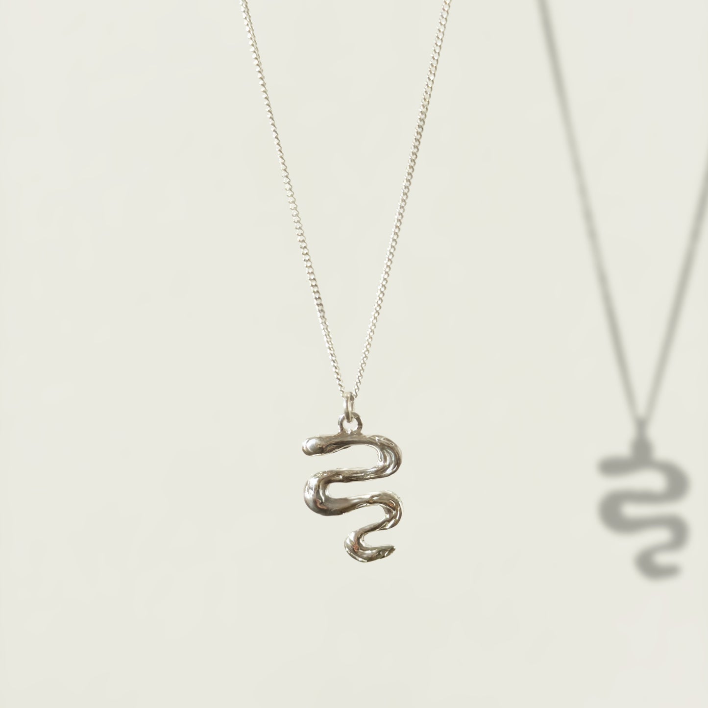 Front view of the Unfold textured silver necklace, pictured on a light plain background.