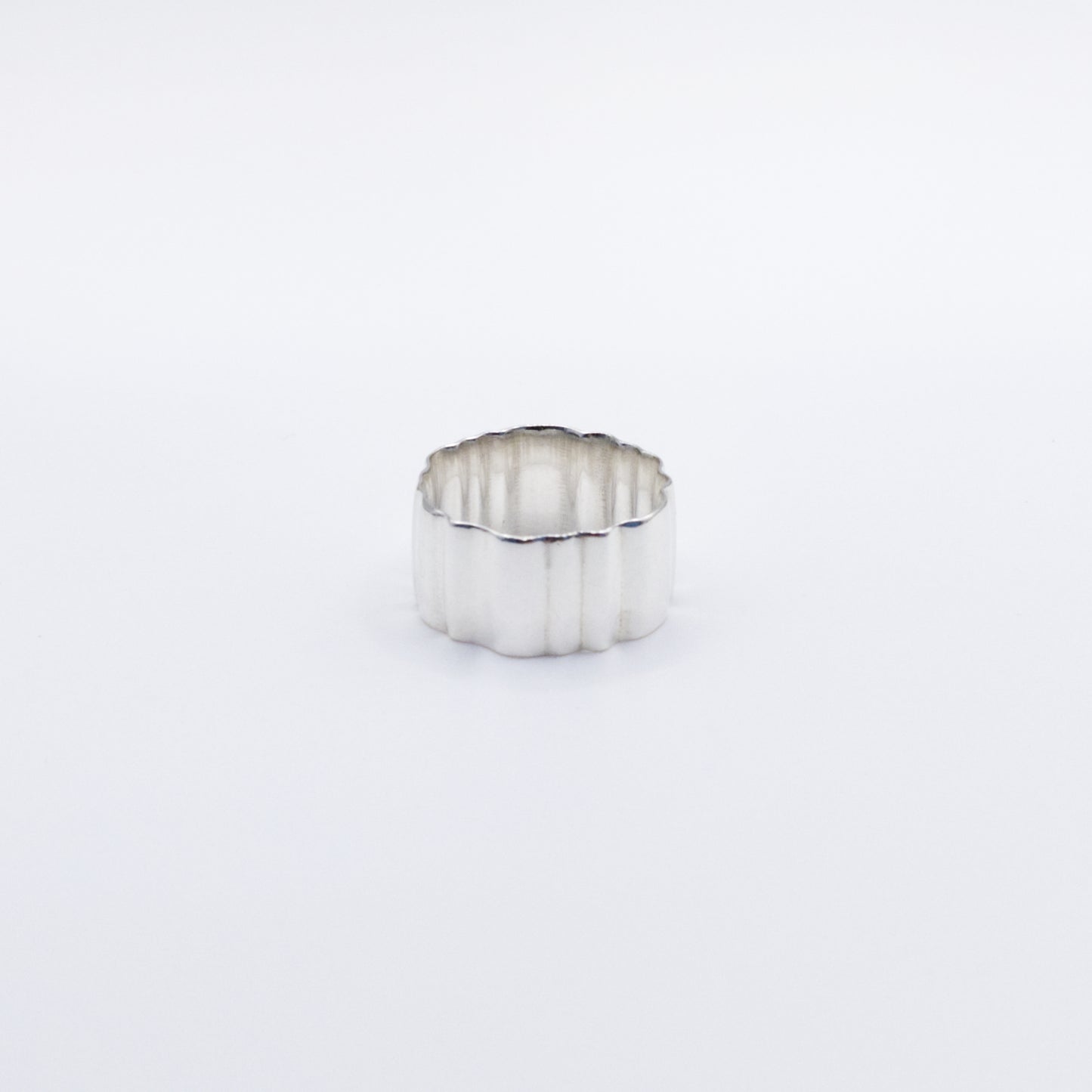 Angled front view of the Wave silver ring, pictured on a light plain background.
