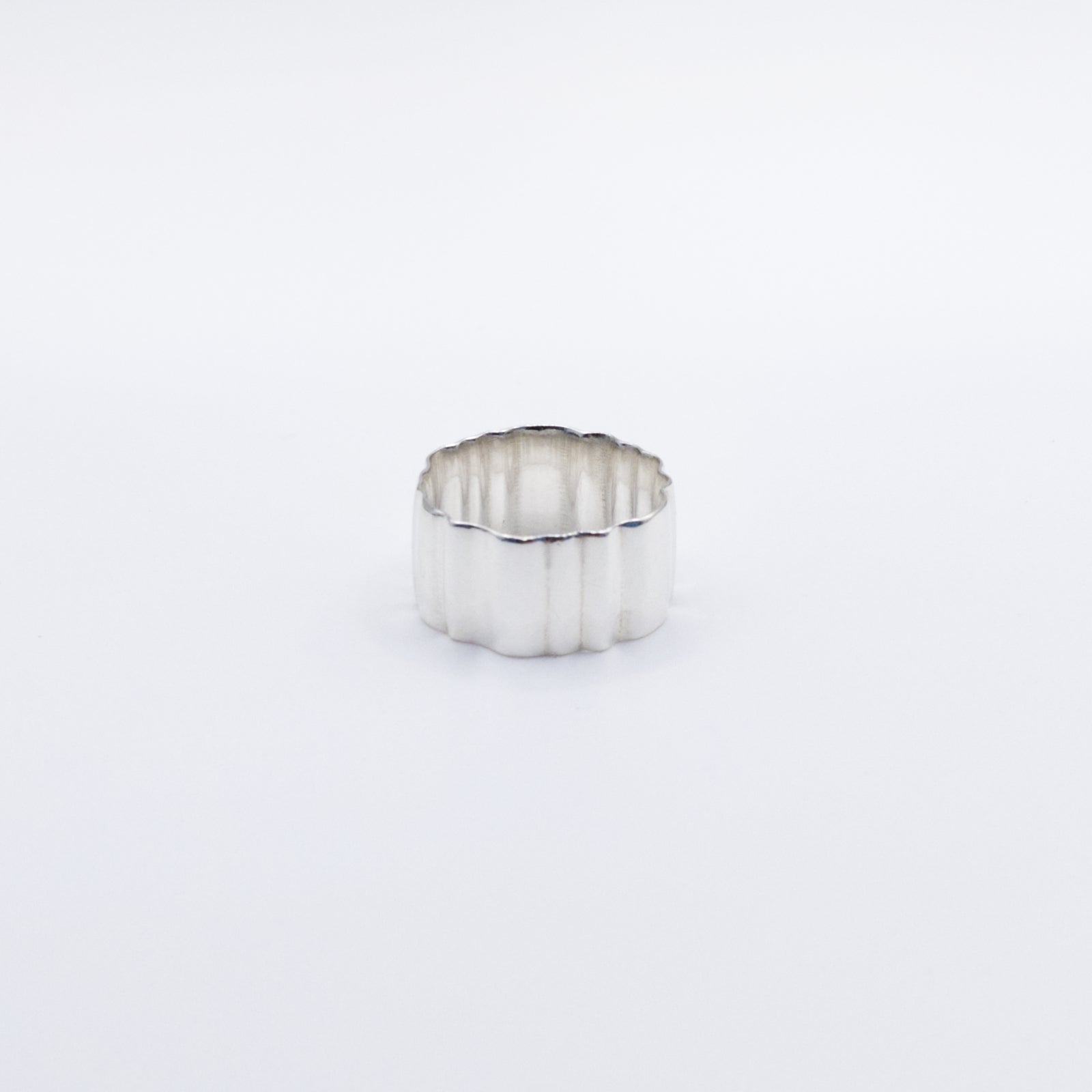 Angled front view of the Wave silver ring, pictured on a light plain background.